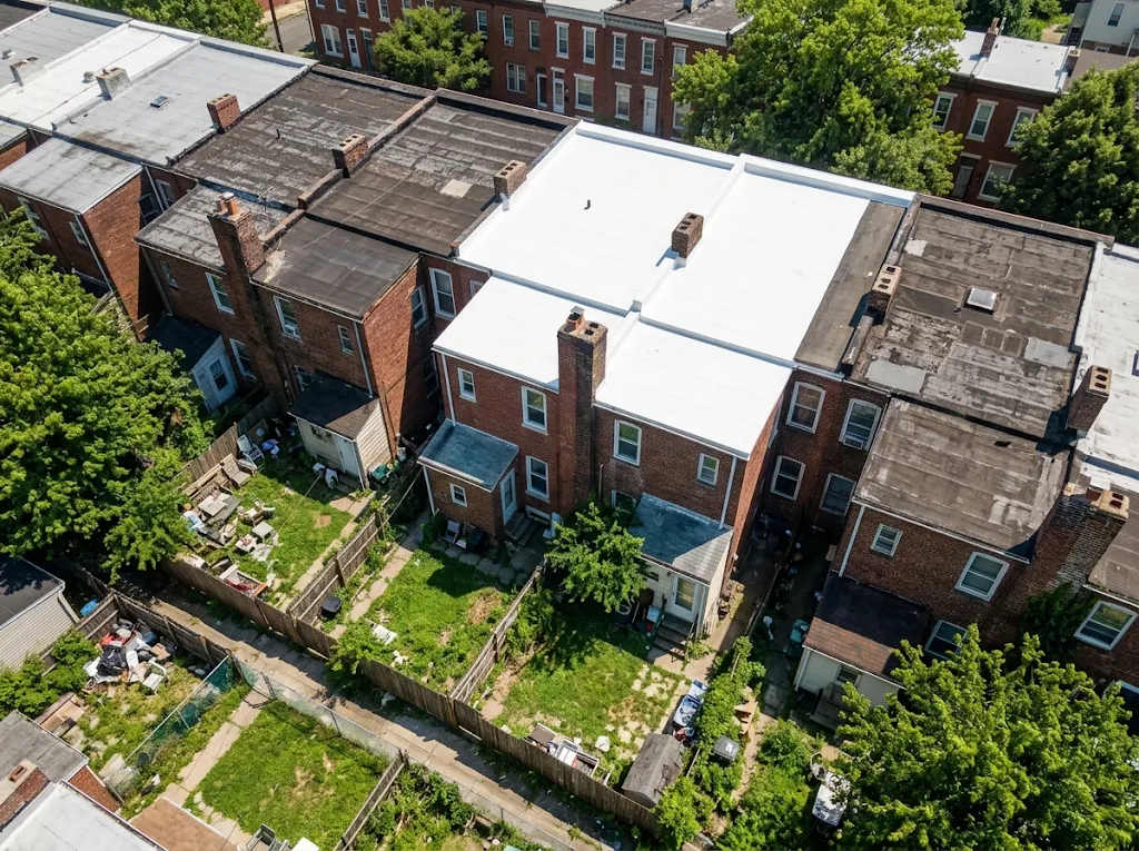 Rear view of attached brick rowhouses with newly replaced white membrane roofs